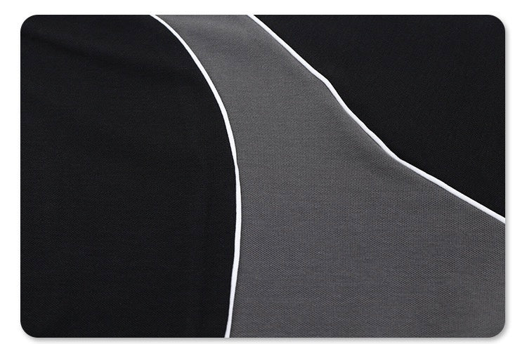 Close-up of a black and gray polo tee with white piping and contrast panel detailing in an oversized athletic fit