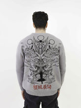 A person with short dark hair is turned away, wearing the Premium Jujutsu Kaisen-Inspired Knit Sweater by Jujutsu Kaisen, featuring a jacquard design of a dragon and temple. Circular symbols hover above the dragon with red Asian characters below, echoing anime streetwear styles.