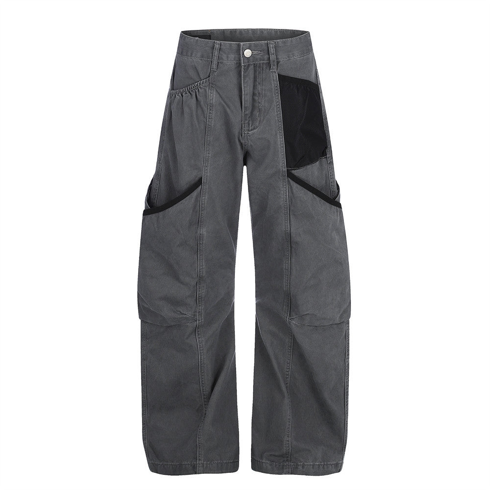Wide-leg cargo pants in washed charcoal grey with contrast black pocket paneling and curved seam detailing, front view