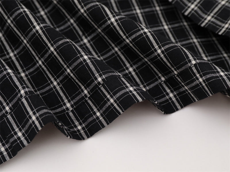 Close-up of black plaid shirt bottom hem with soft drape