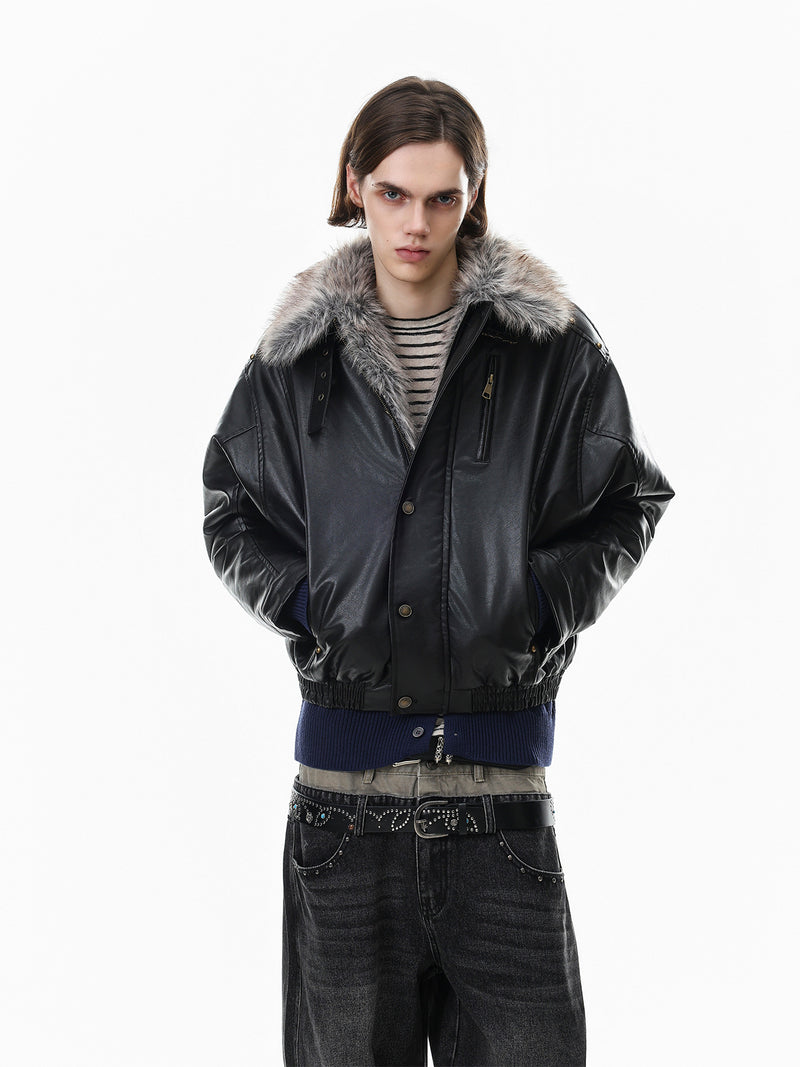 Front view of a model wearing a black faux leather bomber jacket with gray fur collar