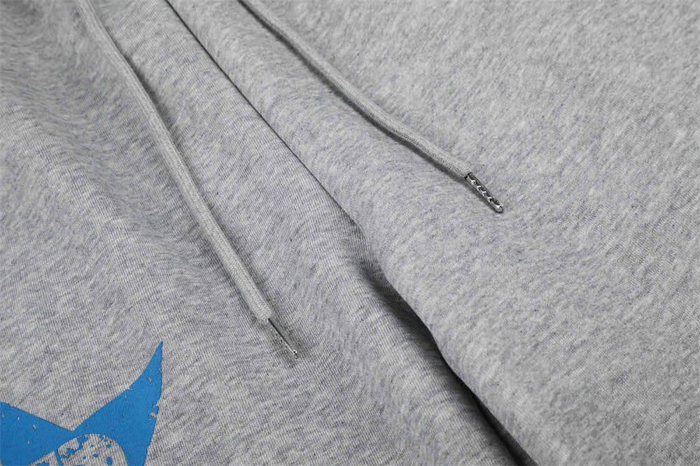 Close-up of gray sweatpants drawstring ends and front seam detail