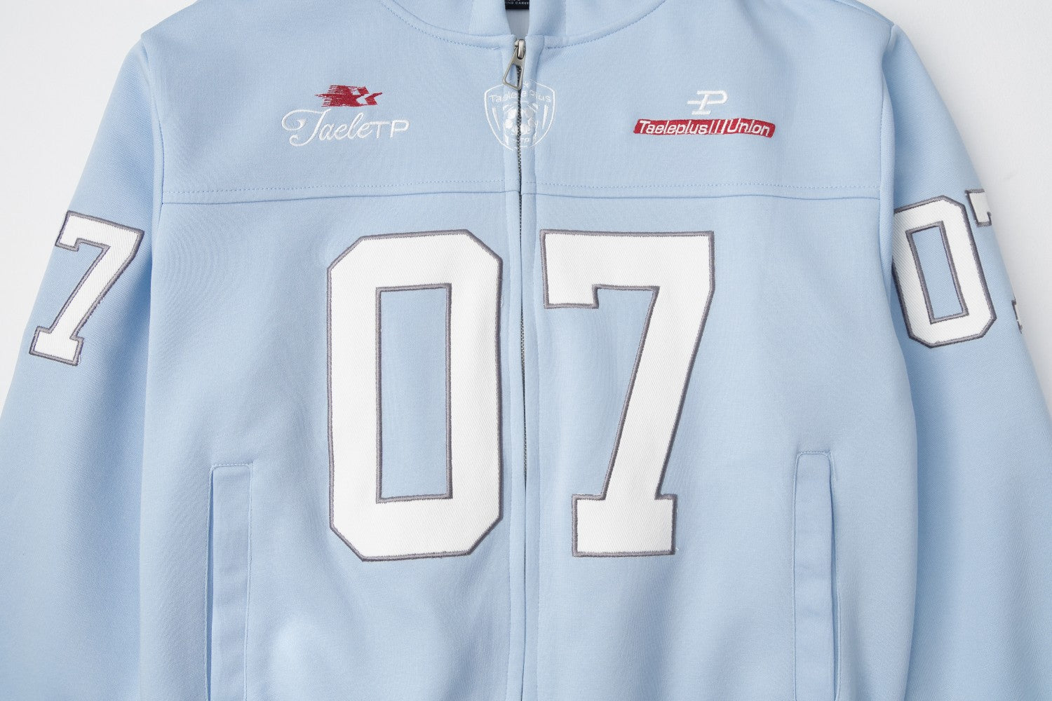 Sweat à capuche bleu zippé intégral avec patch brodé du numéro varsity 07