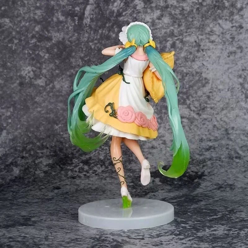 The Hatsune Miku Sleeping Beauty PVC Figure (20cm) showcases long green twin-tail hair, a white dress with a yellow apron, pink flowers, and green vine patterns. It elegantly stands on a circular base against a gray textured background, facing away from the viewer.