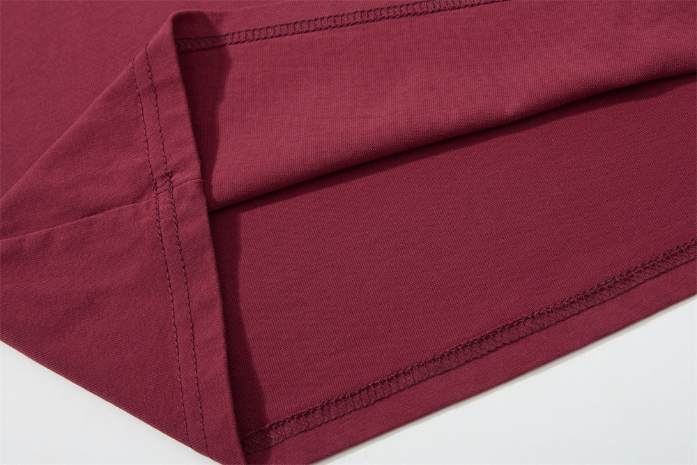 Close-up of stitched sleeve hem on burgundy long sleeve shirt