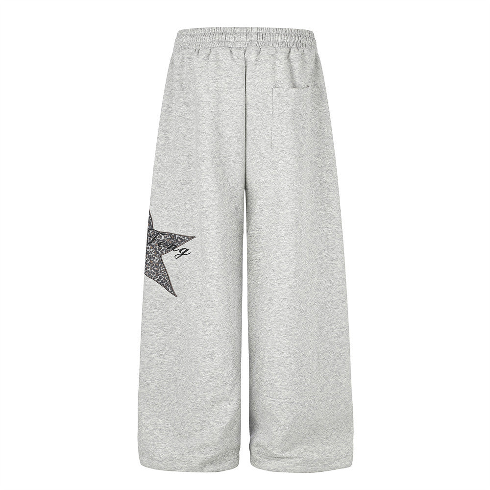 Gray wide-leg sweatpants back view with patch detail peeking from the left leg
