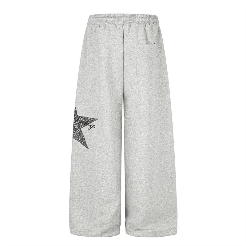 Gray wide-leg sweatpants back view with patch detail peeking from the left leg