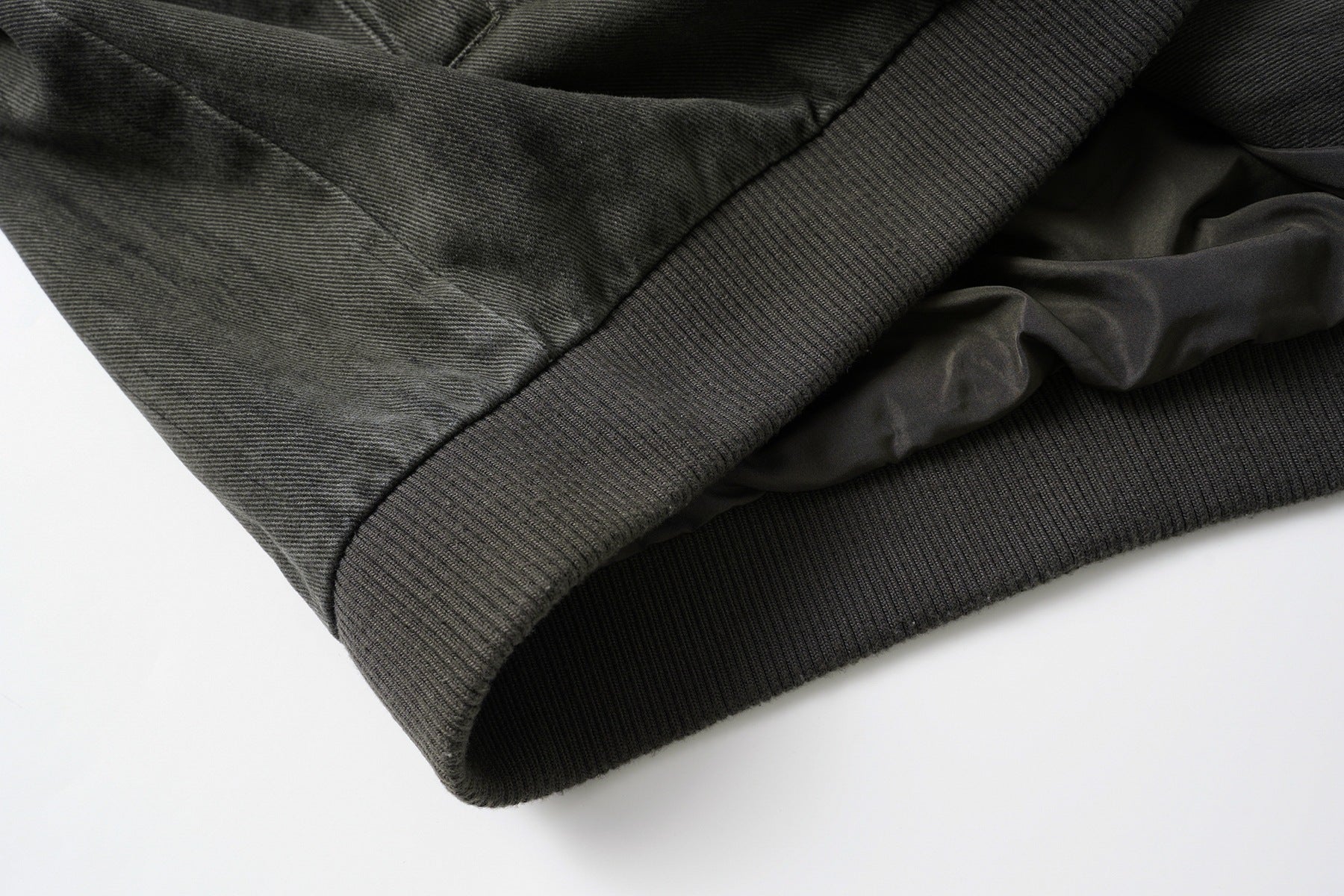 Veste bomber en jean délavé déconstruite à empiècement croisé et coutures effilochées