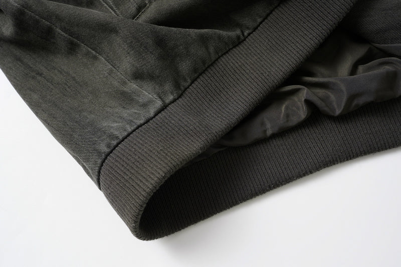 Veste bomber en jean délavé déconstruite à empiècement croisé et coutures effilochées