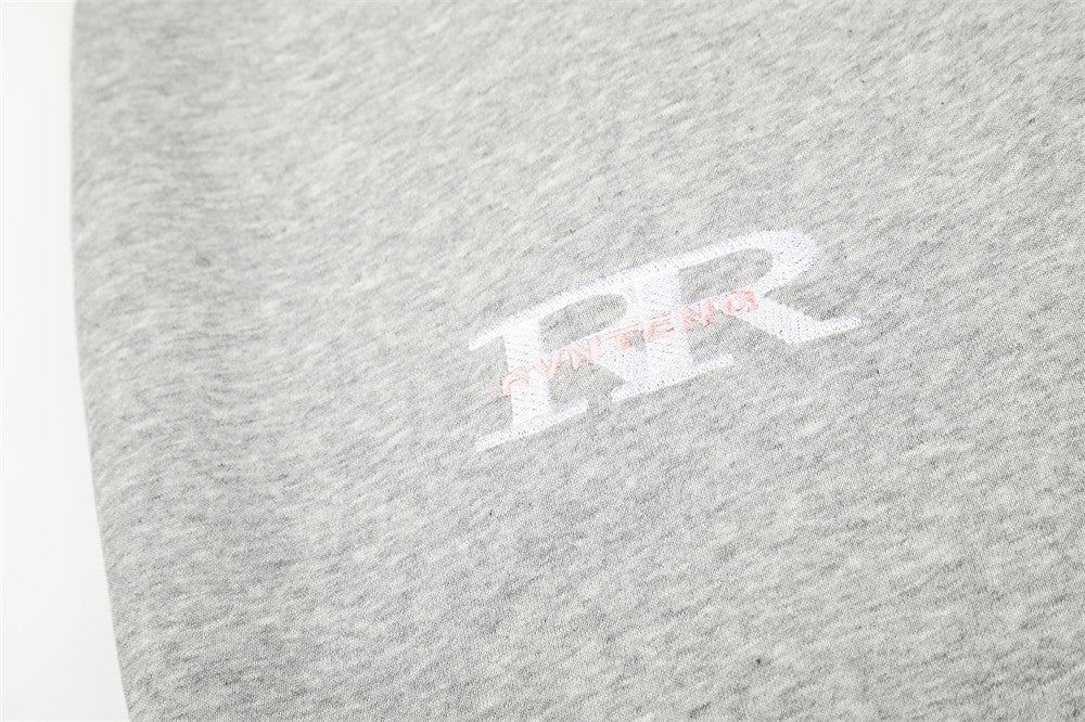 Close-up of white and pink PR-style chest print on heather gray sweatpants