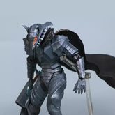 The Berserk Brand Marked Guts Berserker Armor Action Figure is a 16 cm fully poseable PVC statue, featuring a metallic humanoid design with dragon-like armor and a horned helmet. It holds an axe and wears a dark cape against a plain light-colored background, perfect for any fan&