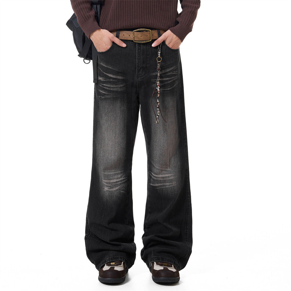 Men's washed distressed wide-leg flare jeans in faded black denim with whisker detailing and relaxed fit