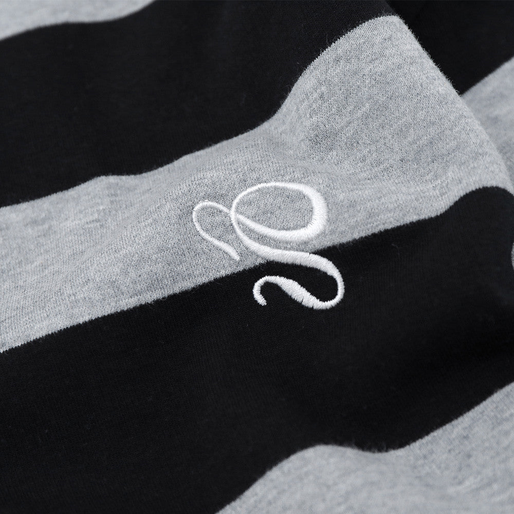 Close-up of embroidered small chest logo on black and gray striped shirt