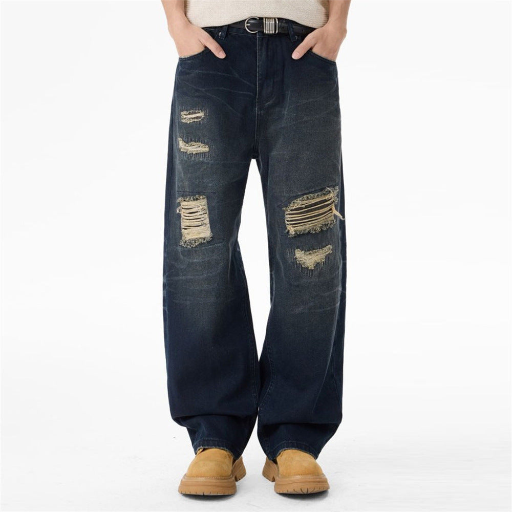 Men's dark wash ripped wide-leg jeans with heavy distressing and raw-thread detailing on both thighs and knees