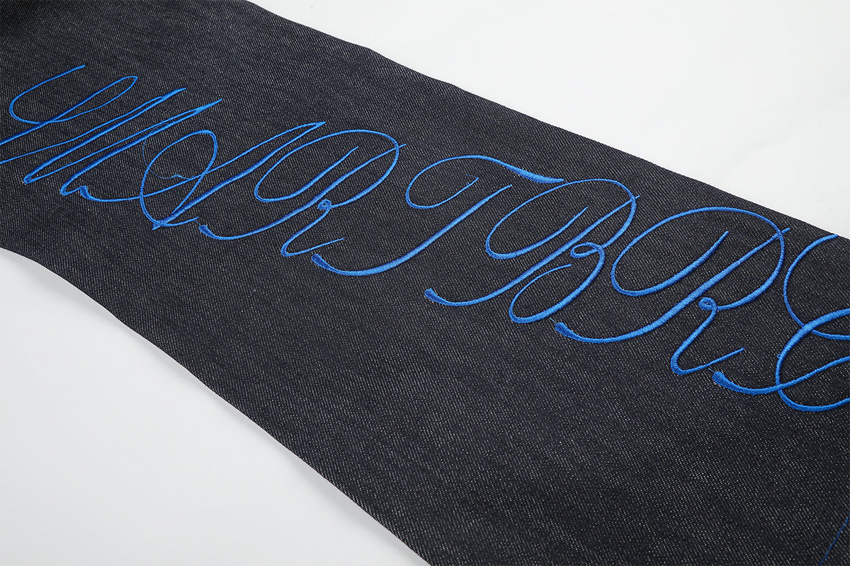 Jean baggy à jambes larges avec broderie bleue effet script et fil barbelé