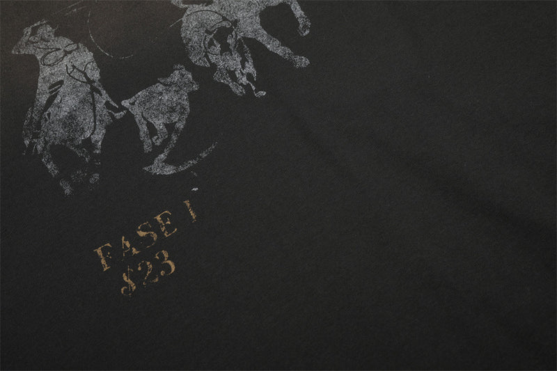 Close-up of lower front print with faded horse graphic and gold text on black shirt