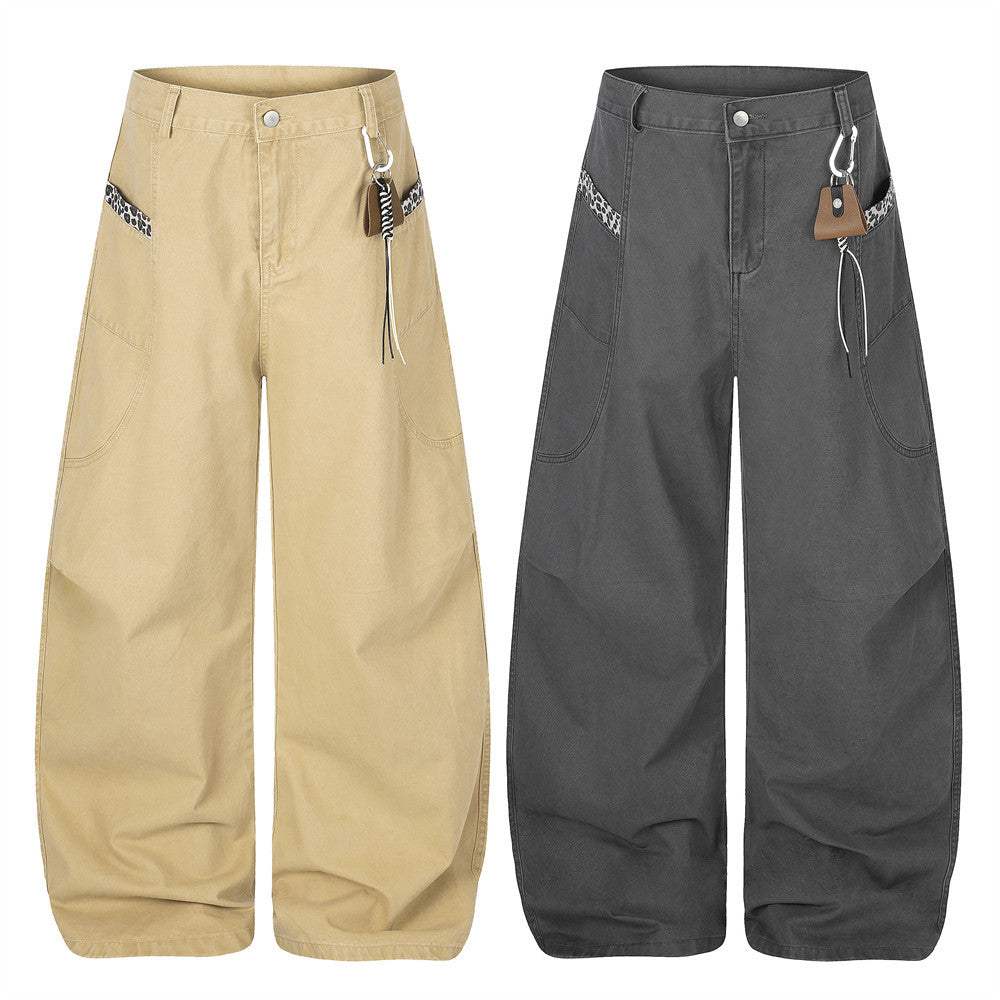 Wide-leg baggy pants in charcoal grey with curved hem, leopard-print pocket trim, and carabiner clip waistband detail