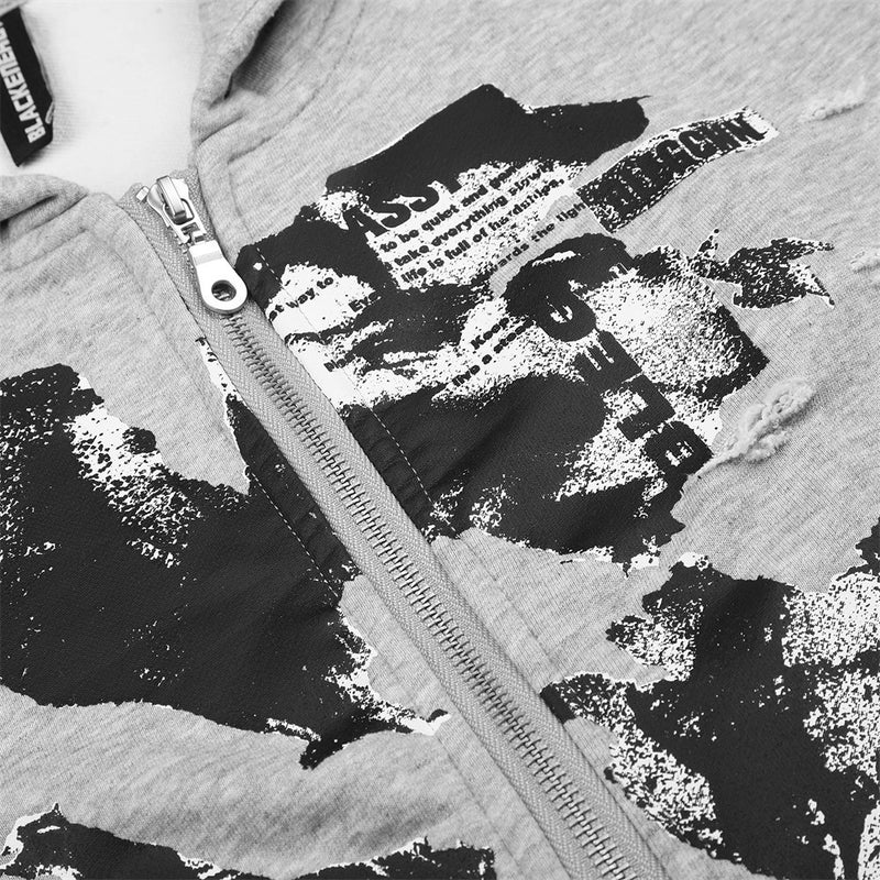 Close-up of light gray hoodie front with abstract black and white graphic print and metal zipper