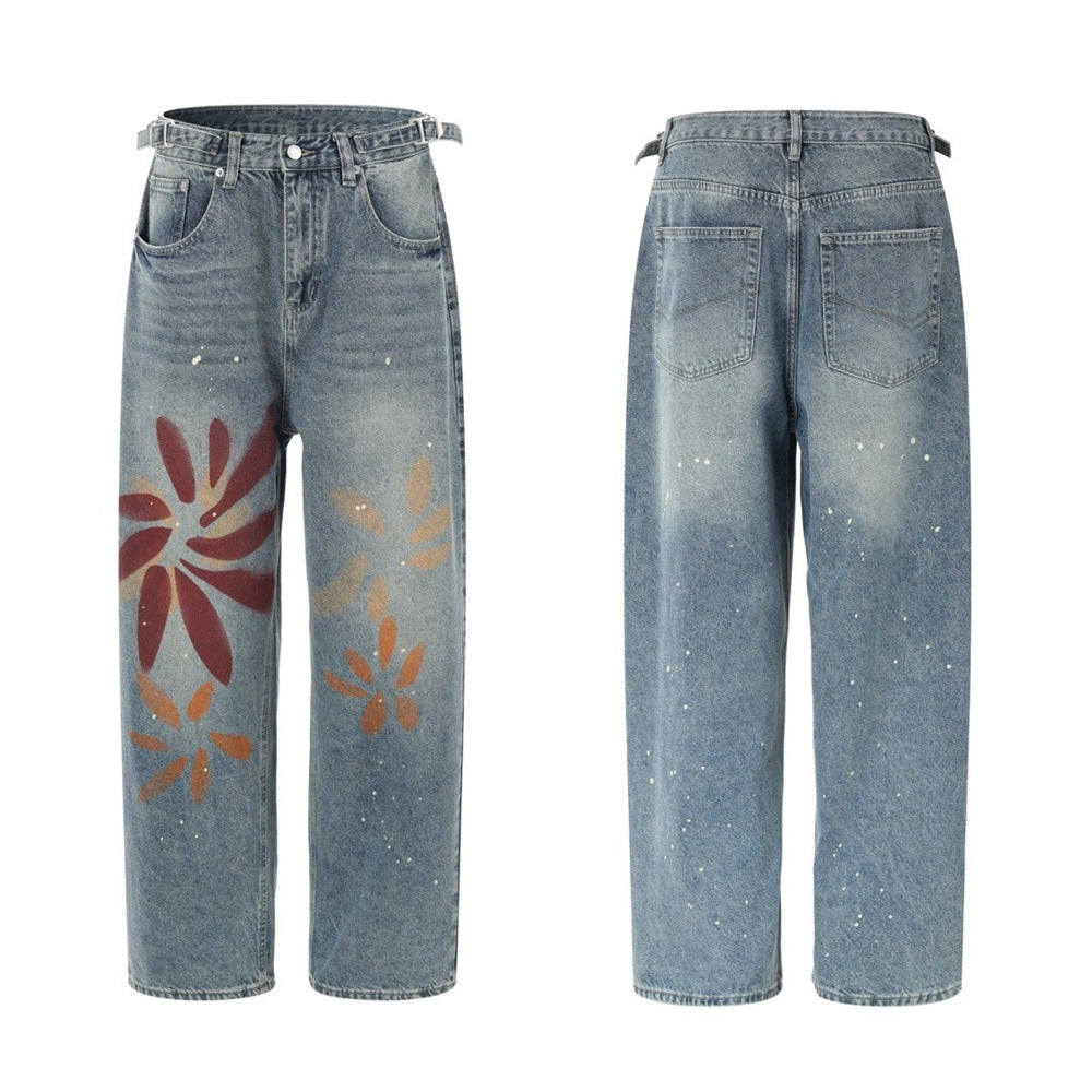 Men's wide-leg relaxed fit jeans in washed blue denim with floral graffiti print in burgundy, amber, and orange