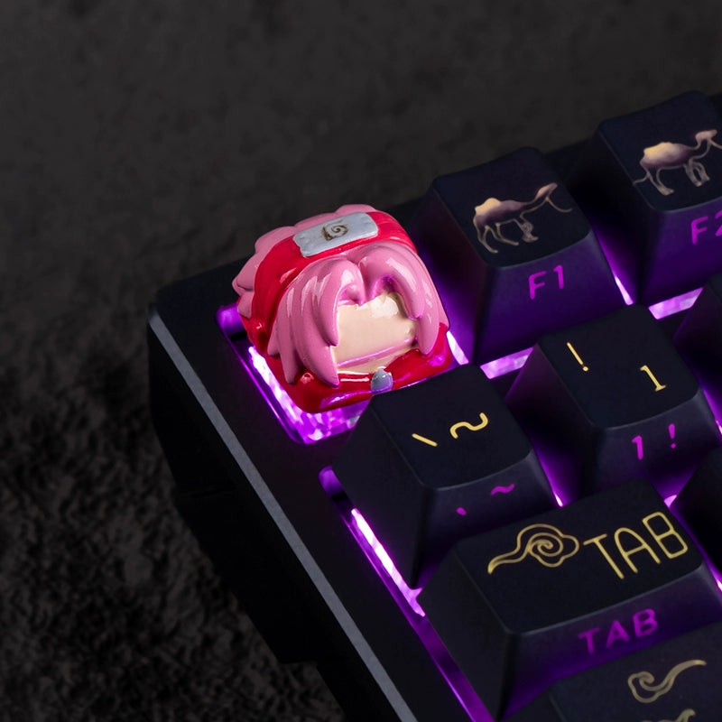 The close-up of a mechanical keyboard highlights vibrant purple backlighting, with the Escape key featuring a custom resin keycap shaped like a pink-haired cartoon character in red attire, inspired by the Team 7 Naruto Keycap Set by Naruto.