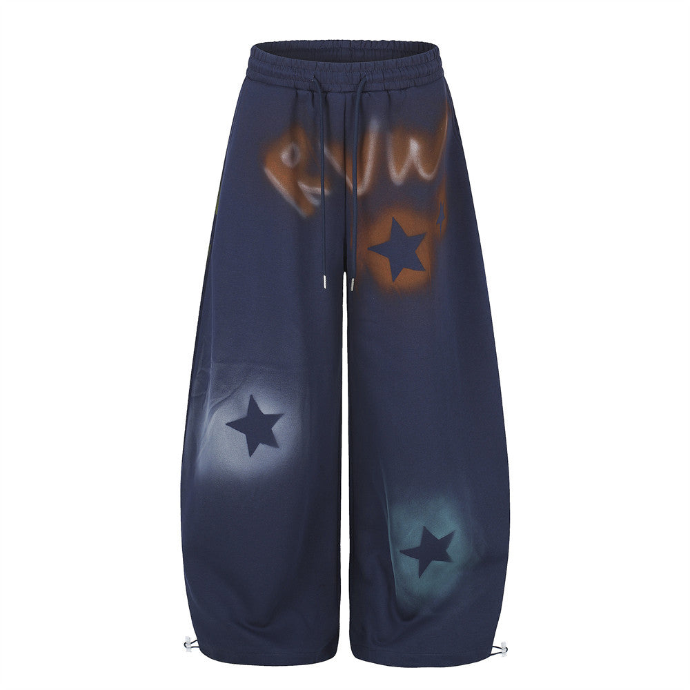 Men's oversized wide leg sweatpants with spray-dye graffiti star print in navy, front view