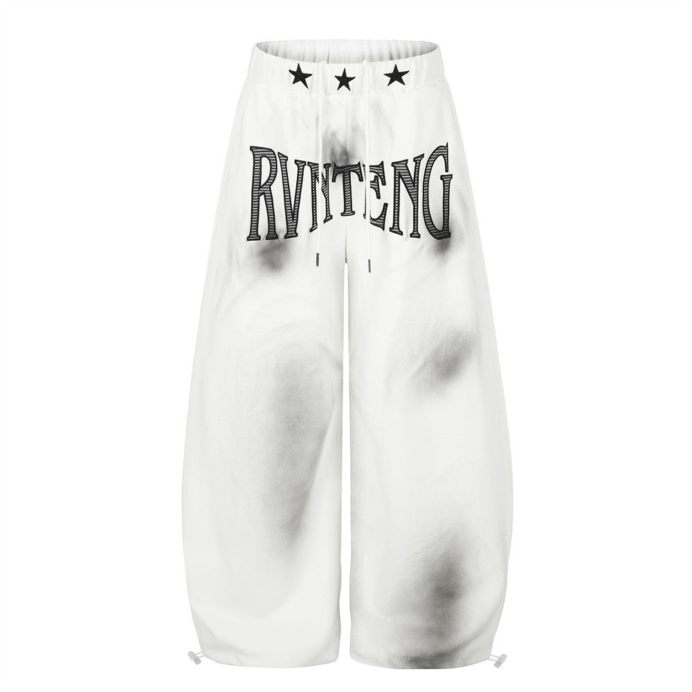 Pantalones de chándal baggy de pierna ancha RVNTENG con lavado efecto humo de pintura en aerosol y gráfico de letras en color blanco, vista frontal