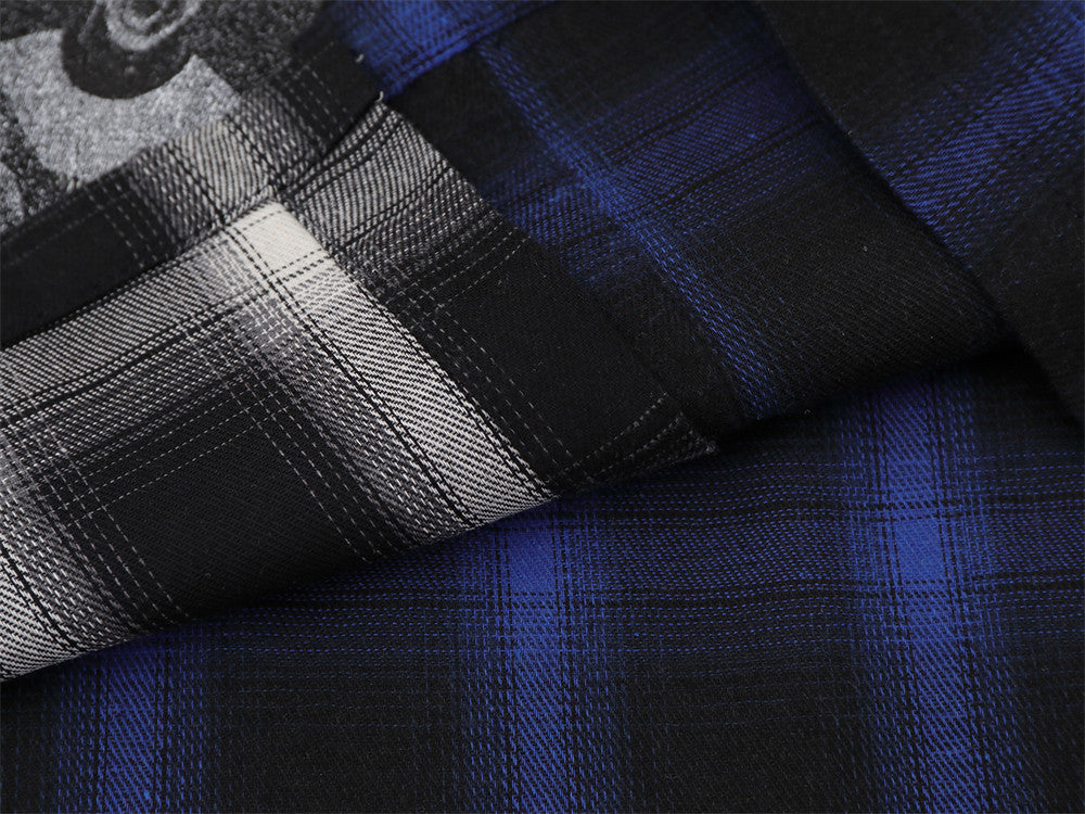 Close-up of plaid fabric texture on blue and black shirt with layered sleeve cuff