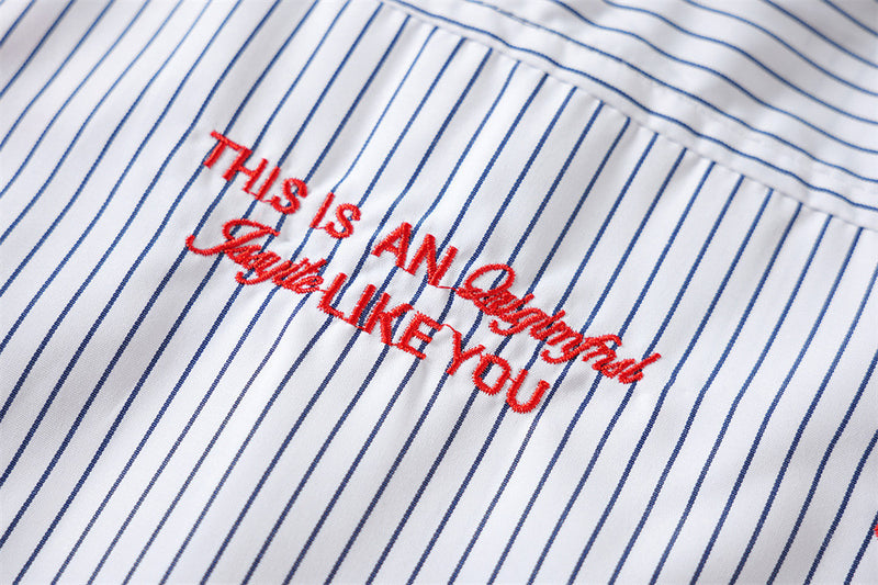 Close-up of red embroidered slogan text on striped shirt back