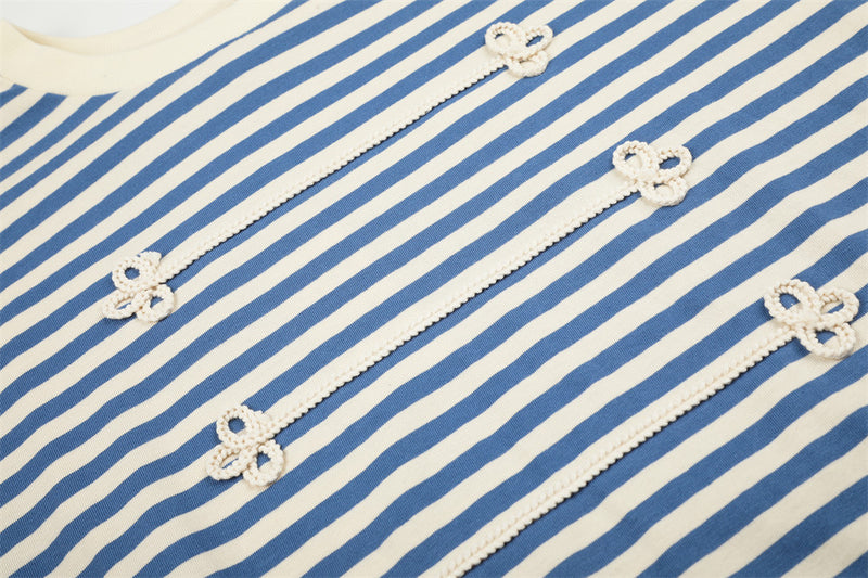Close-up of blue and cream striped shirt front with floral knit trim details