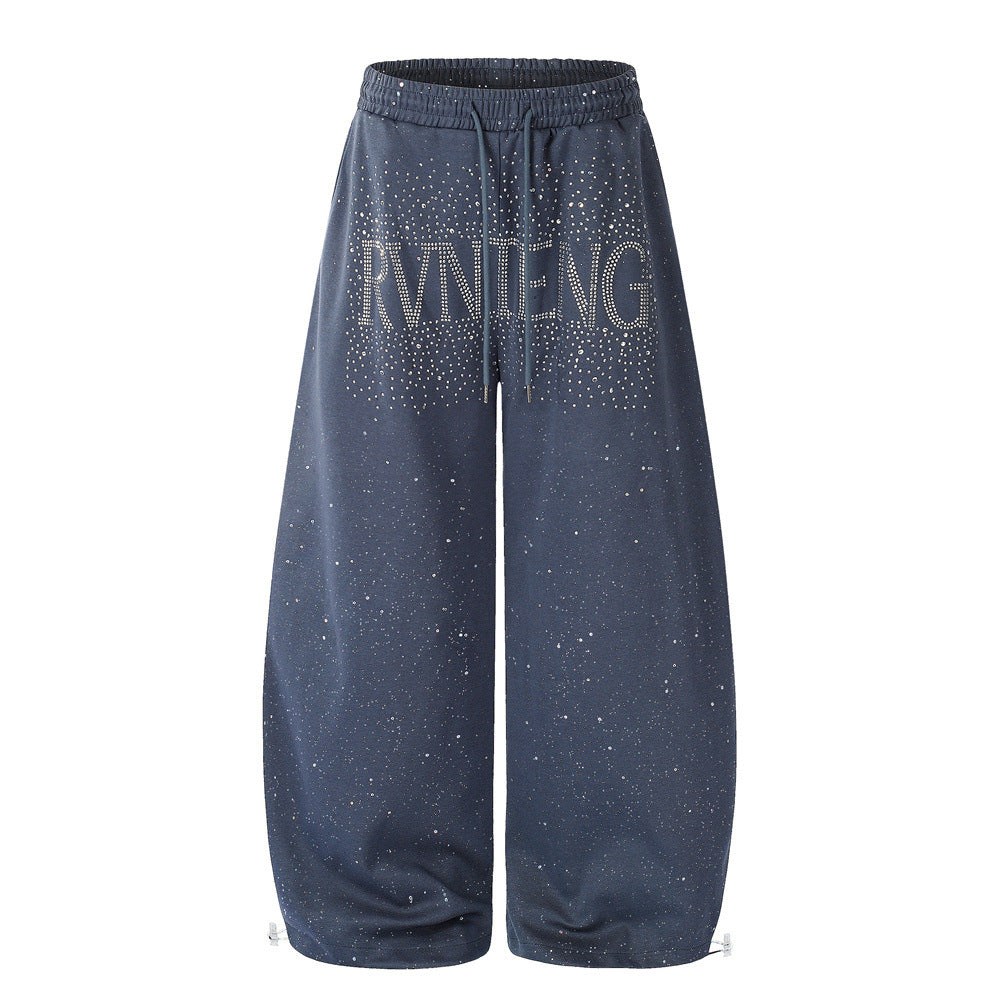 Men's wide-leg sweatpants with all-over rhinestone starry print and large hotfix letter graphic on front, shown in navy blue