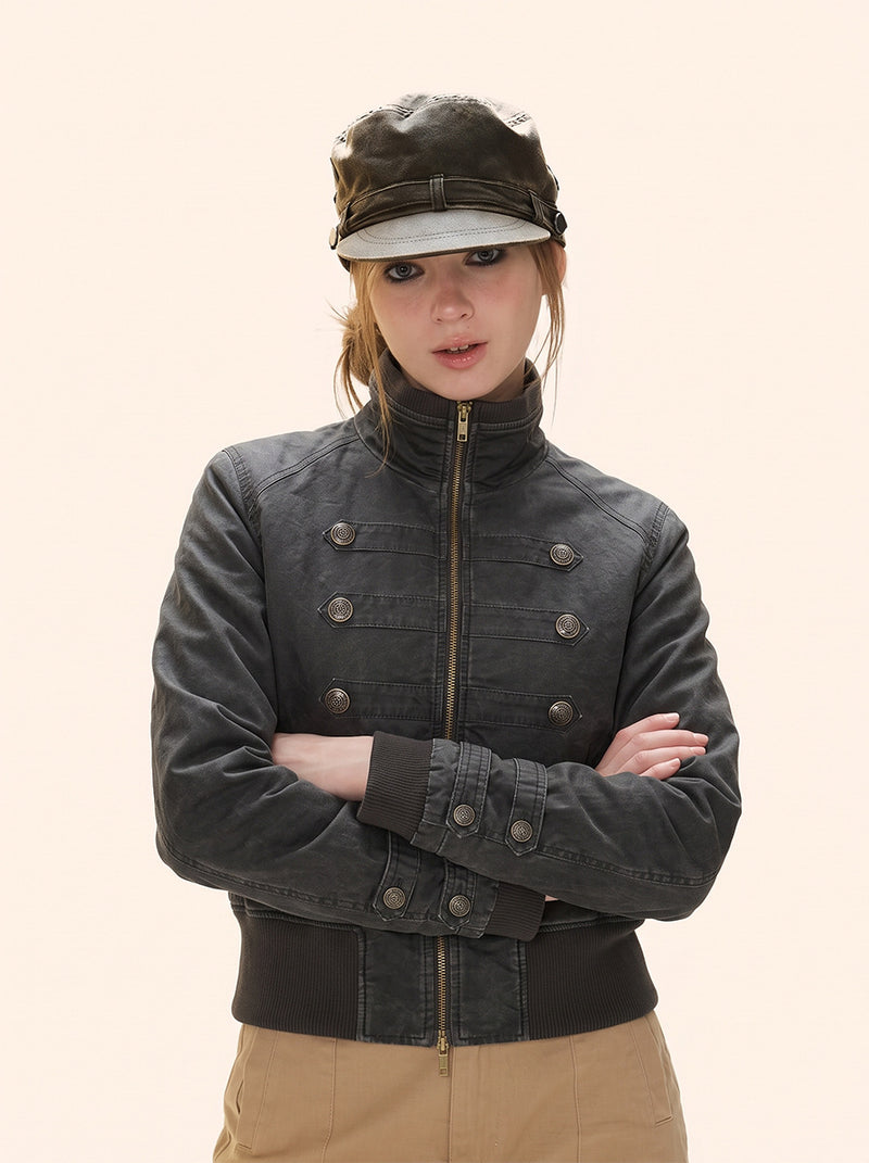 Cropped military-style padded bomber jacket in washed charcoal grey with stand collar, double-breasted brass buttons, and rib