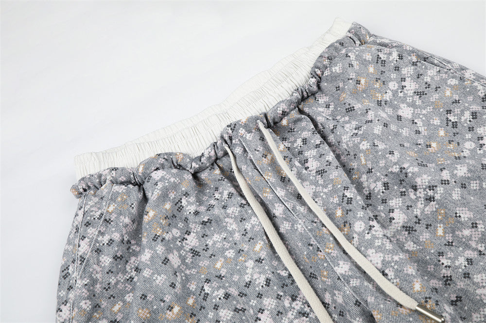 Close-up of floral print pants waistband with cream drawstring and ruched elastic trim