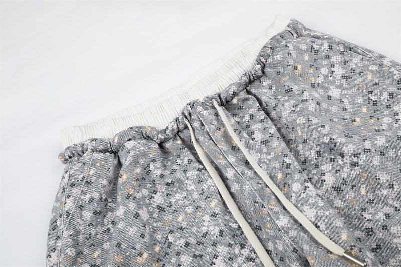 Close-up of floral print pants waistband with cream drawstring and ruched elastic trim