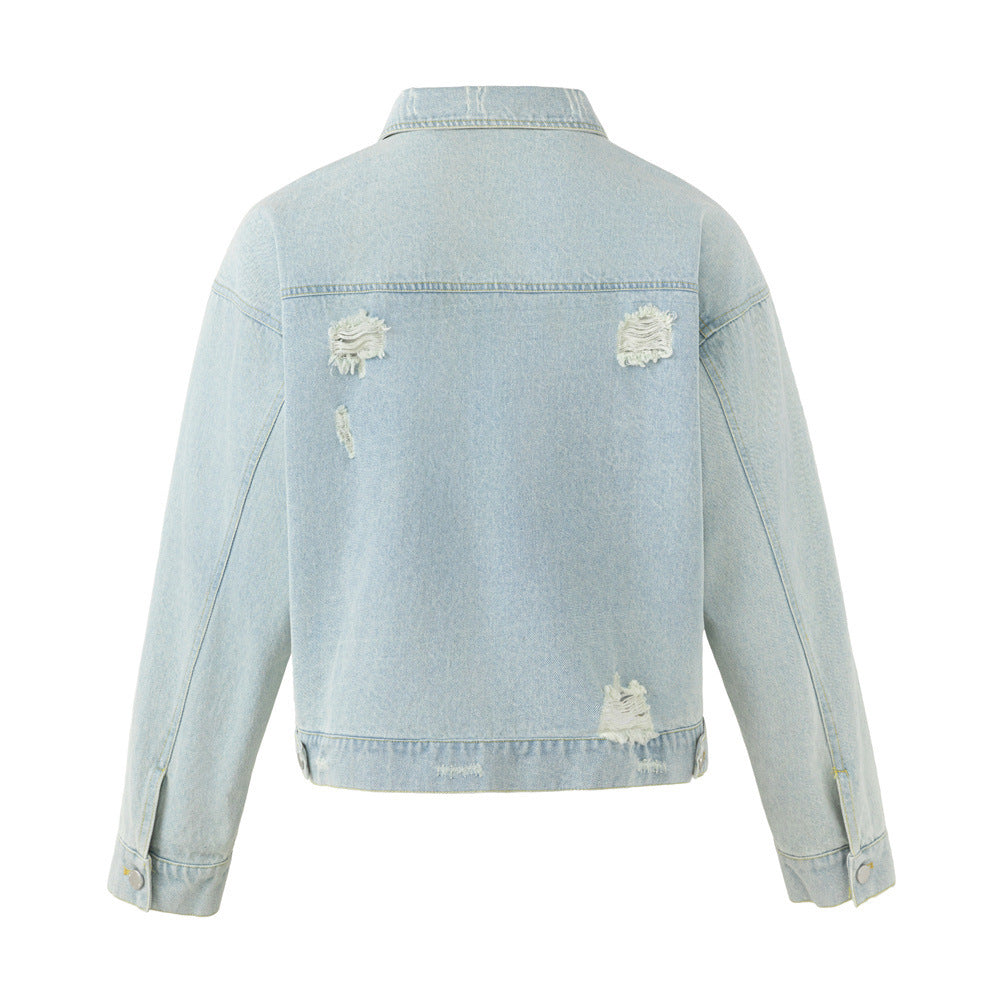 Back view of a light wash denim jacket with frayed patches across the shoulders and lower hem