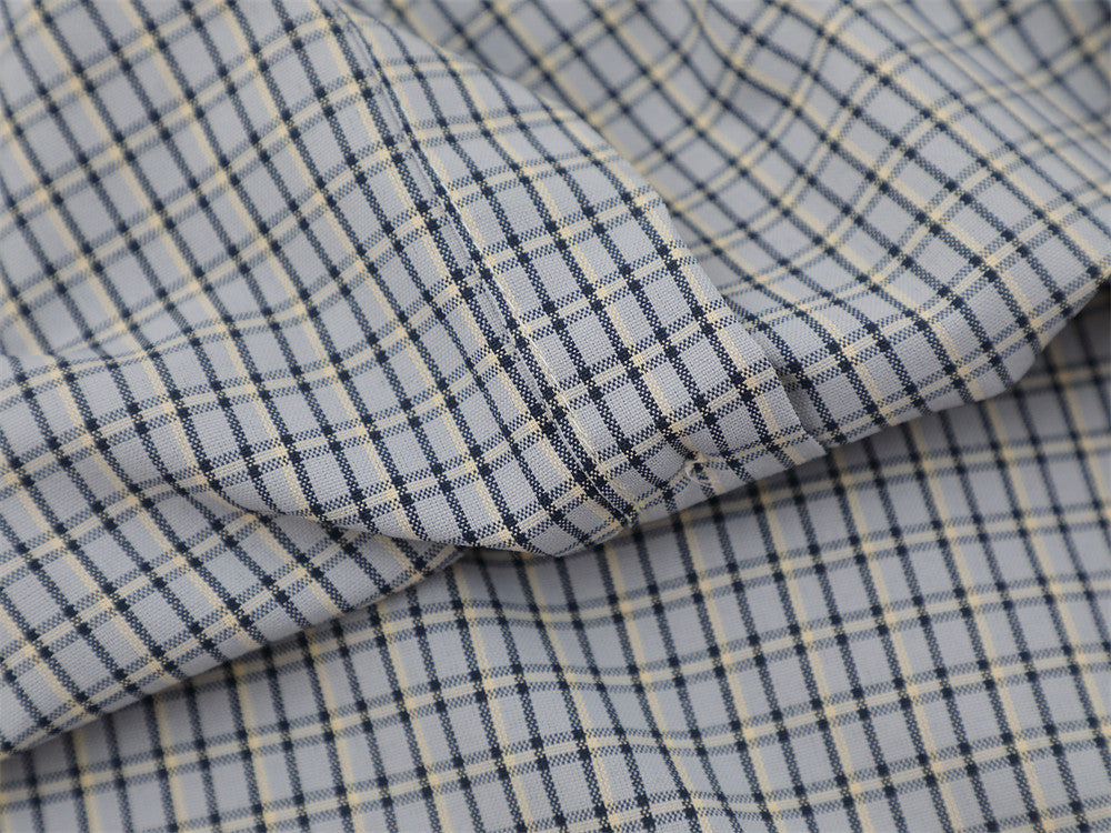 Close-up of folded gray plaid fabric with visible seam and soft drape