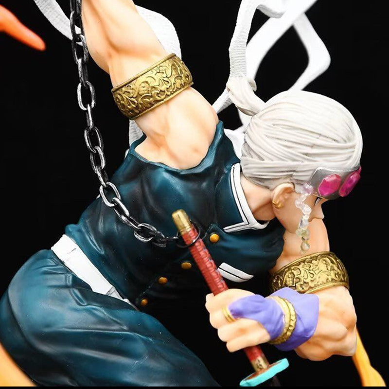 The Premium Demon Slayer Urogi Figure, a 37cm GK model, presents detailed silver hair, purple goggles, ornate arm bands, and a dark sleeveless top. Striking an action pose with a red sword and bandaged arms against a black backdrop, it features USB light-up effects for dramatic appeal.