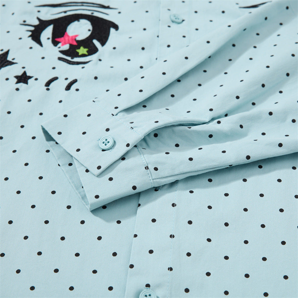 Close-up of the light blue shirt sleeve cuff and embroidered eye detail