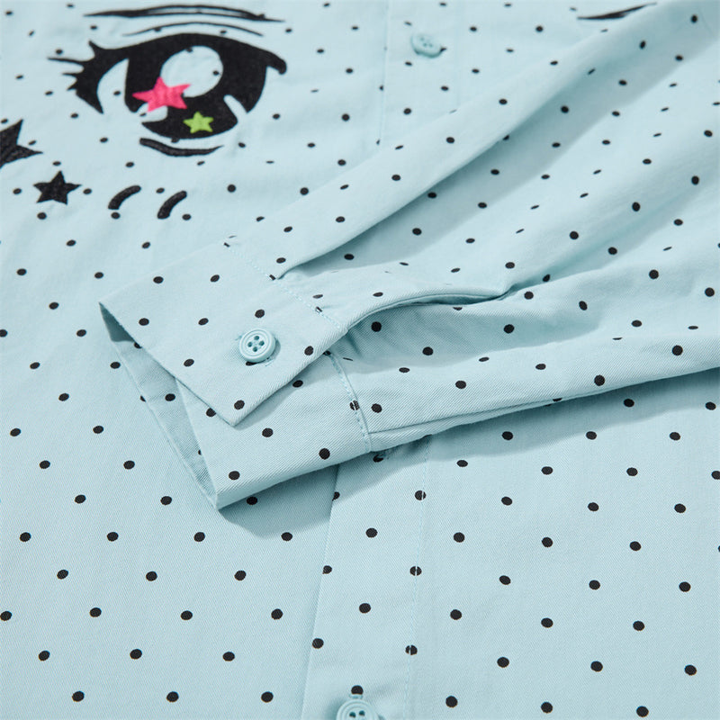 Close-up of the light blue shirt sleeve cuff and embroidered eye detail