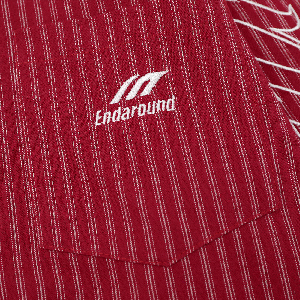 Close-up of chest pocket on red striped shirt with white embroidered logo