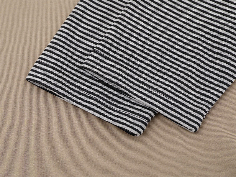 Close-up of black-and-white striped sleeve cuff on khaki polo shirt