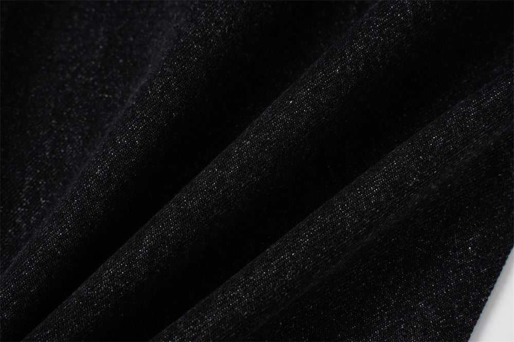 Close-up of black denim fabric texture with soft folded drape