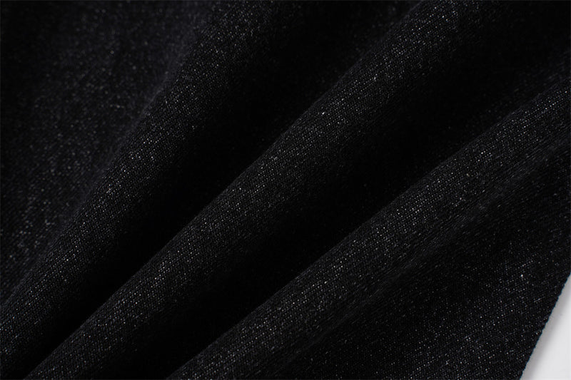 Close-up of black denim fabric texture with soft folded drape