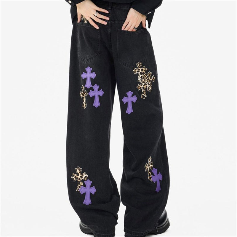 Black baggy jeans with purple and leopard cross patches, back view on model