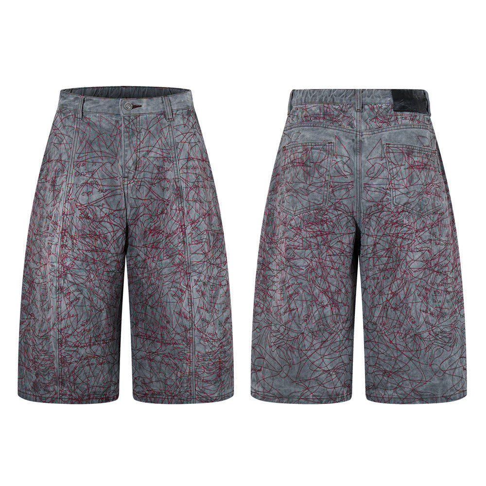 Wide-leg washed grey denim shorts with all-over burgundy red graffiti embroidery, front and back view