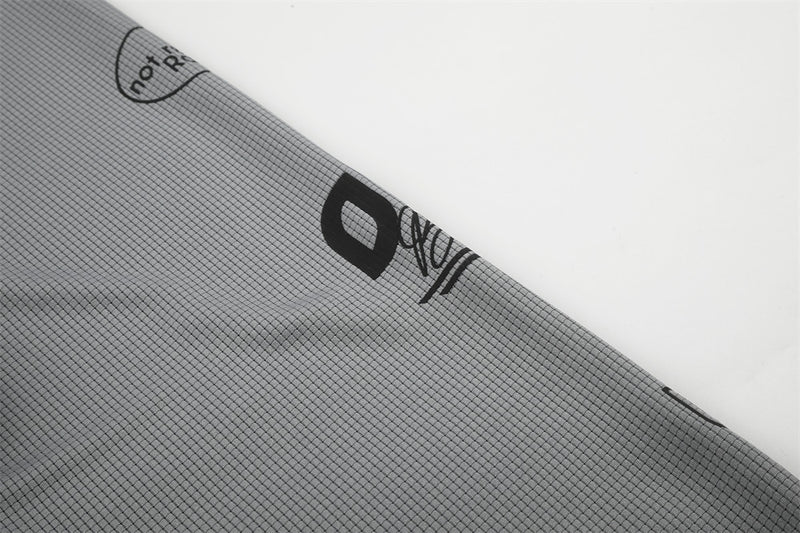 Close-up of gray sleeve showing black logo print and not refined rain text