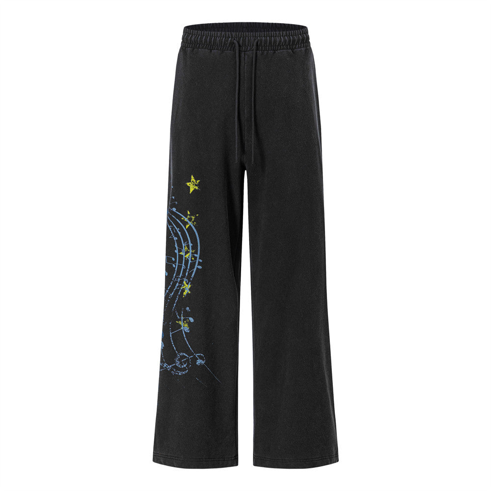 Men's wide-leg sweatpants with music note and star graphic print in washed black, front view