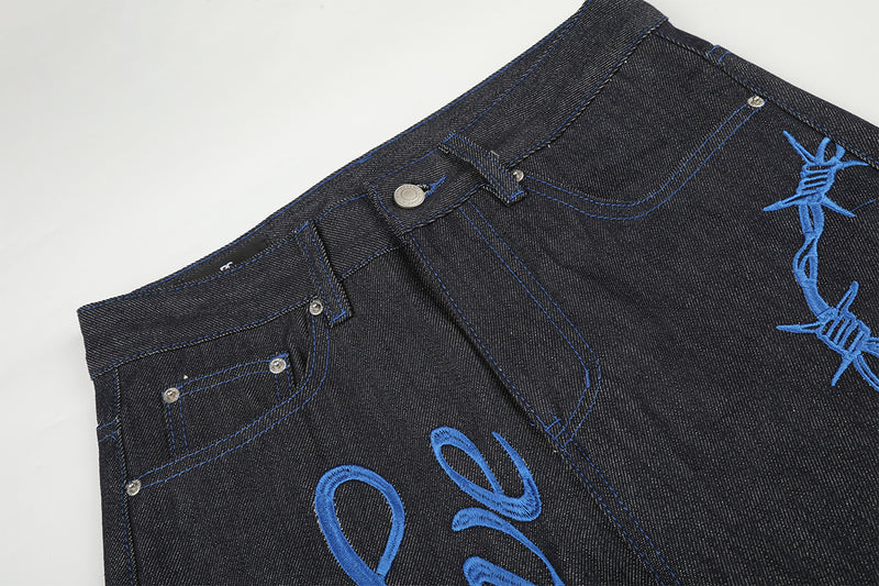 Jean baggy à jambes larges avec broderie bleue effet script et fil barbelé