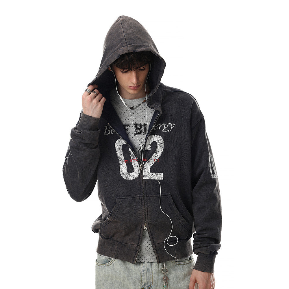 Model wearing black distressed zip-up hoodie with hood up and front graphic visible