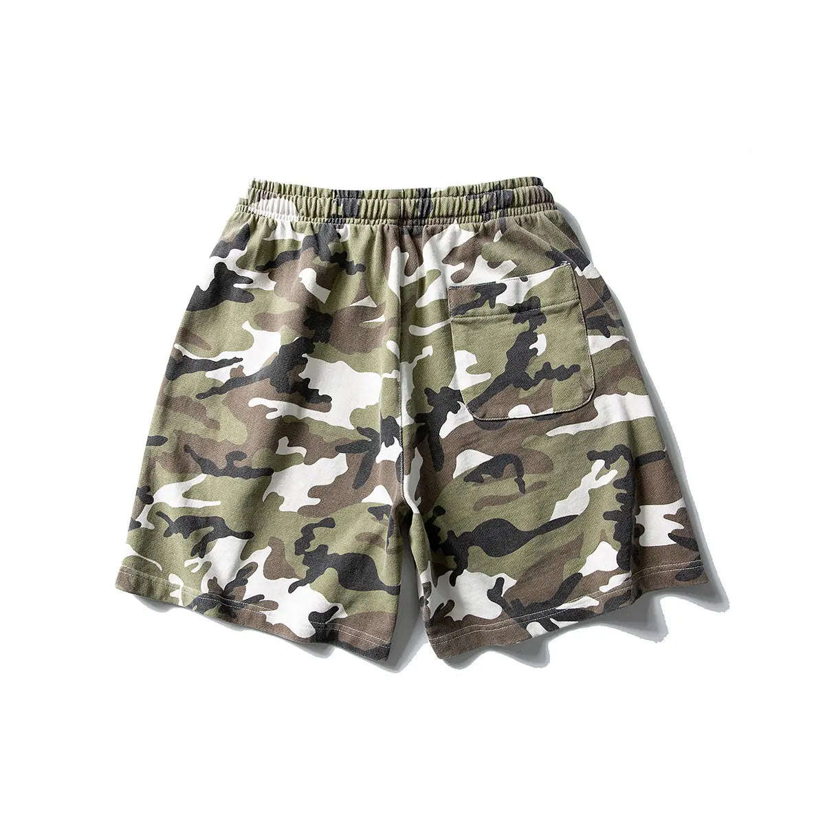 Men's Woodland Camo Cotton Drawstring Shorts in green, brown, black, and white, featuring an elastic waistband, back pocket, and relaxed fit. Shown on a plain white background.