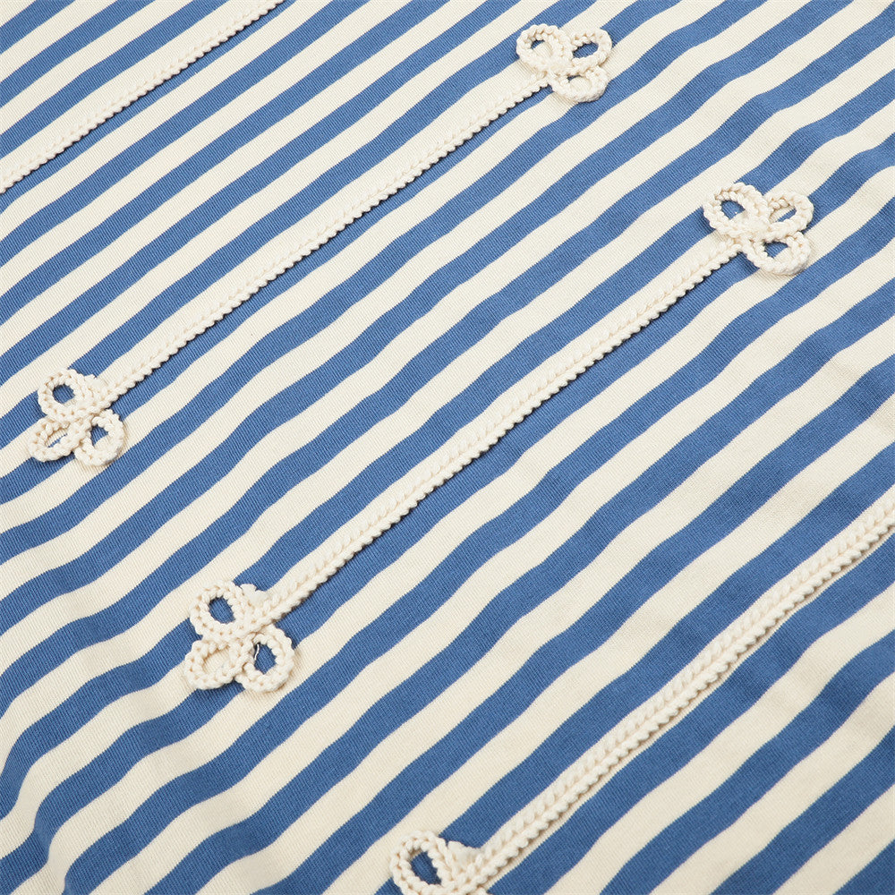 Close-up of blue and cream striped shirt front with repeated floral knit trim details